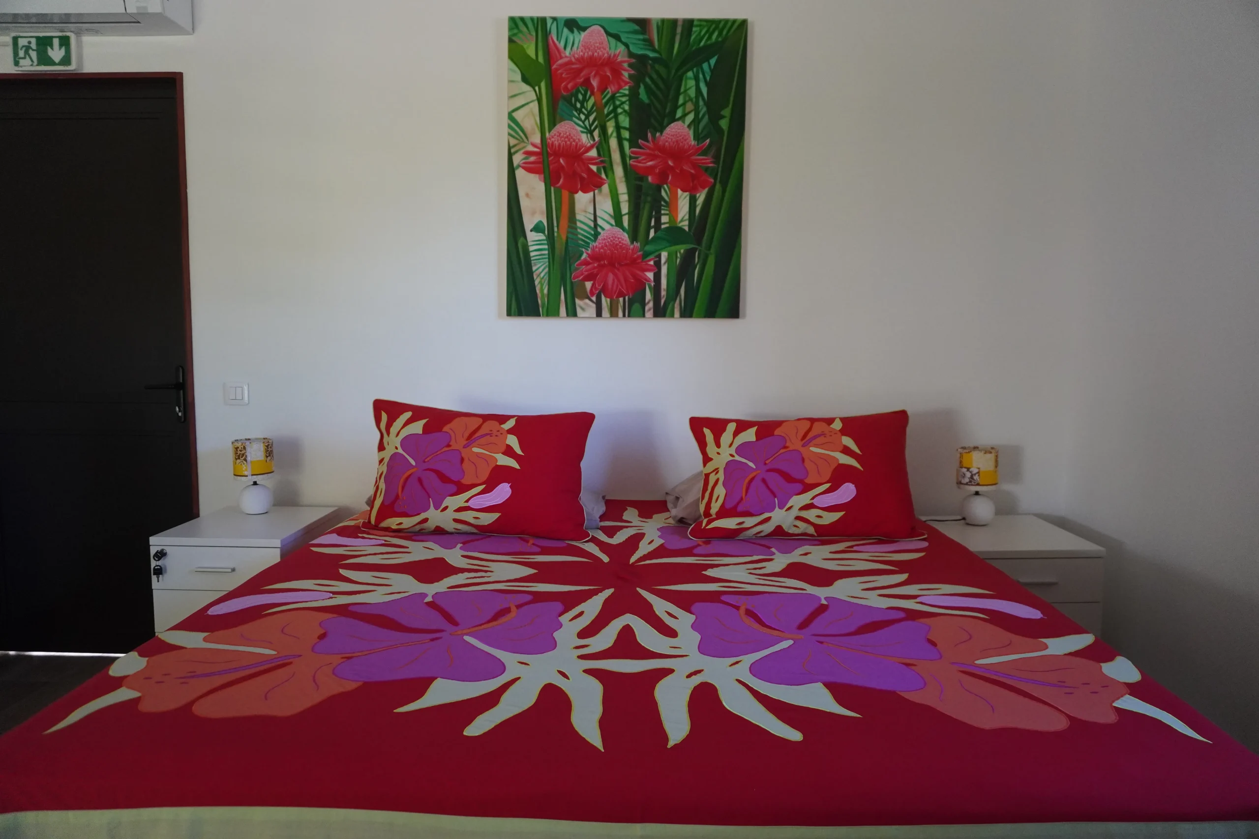 Chambre MOANA 5 - lit double - Teahupo'o, Tahiti Le bungalow Tipanier, mur fuchsia, tifaifai violet et rose.